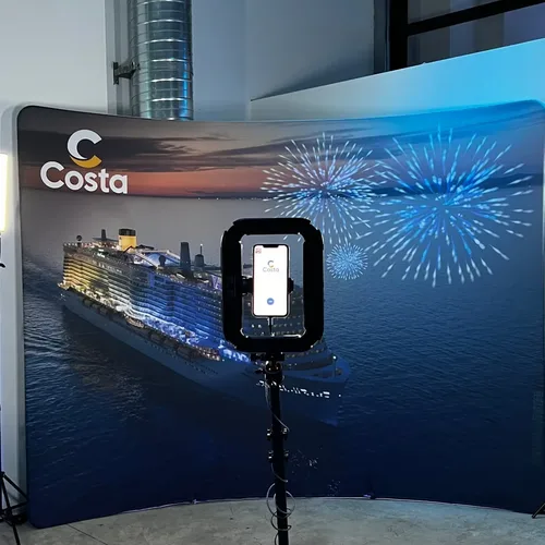 Photocall personalizado con la marca Costa Cruceros detrás del fotomatón